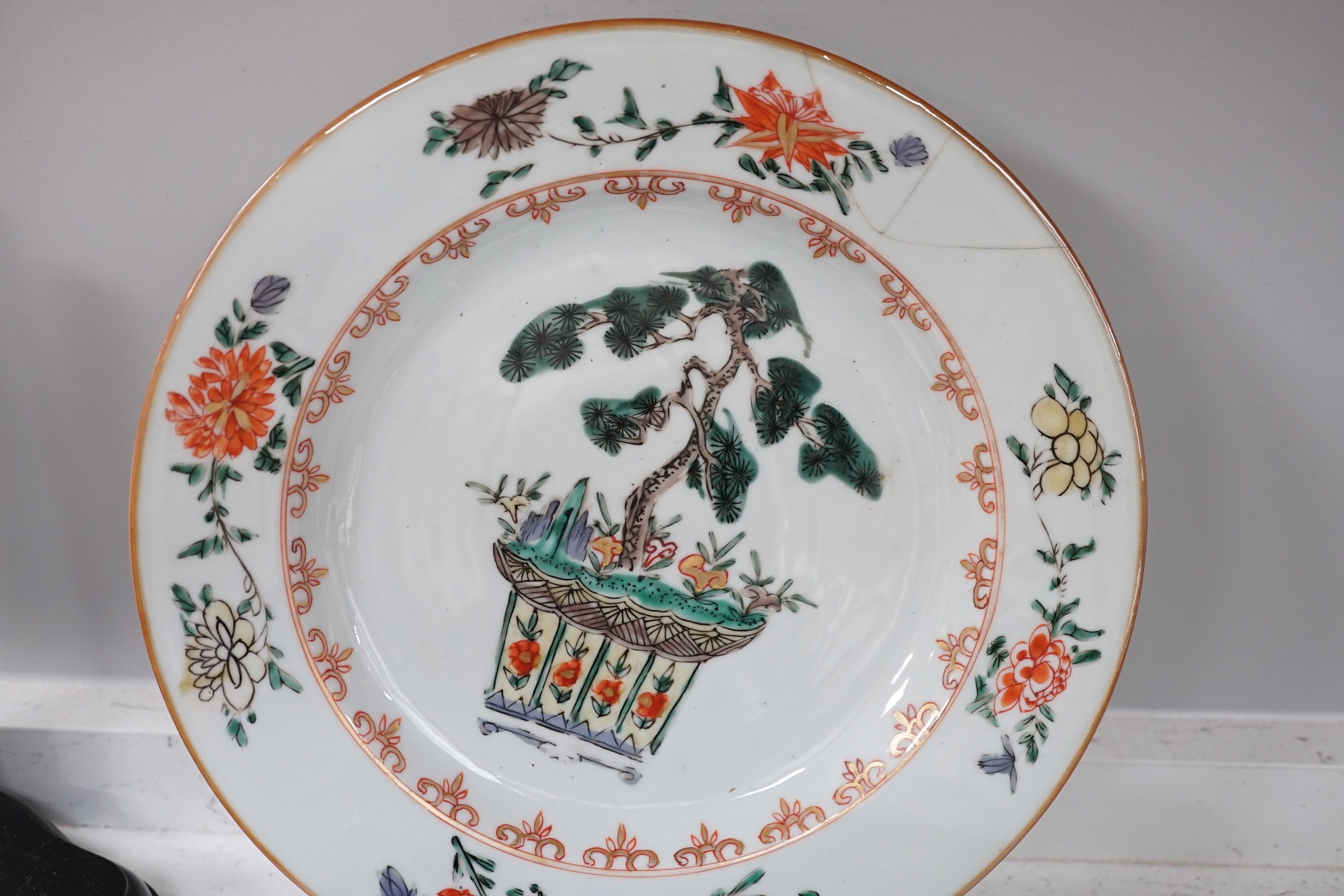 An 18th century Chinese export famille verte plate, Kangxi period Japanese carved wood stand and other various Chinese wood stands